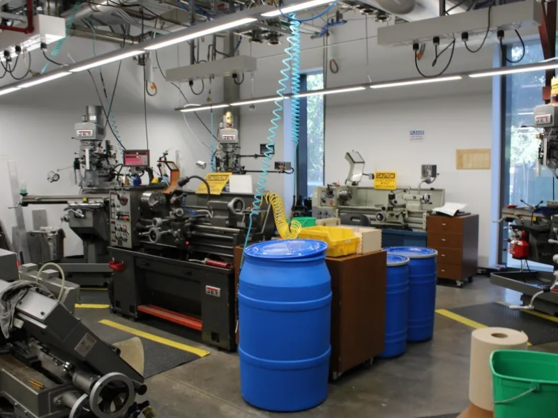 Concrete room with large machinery and storage barrels