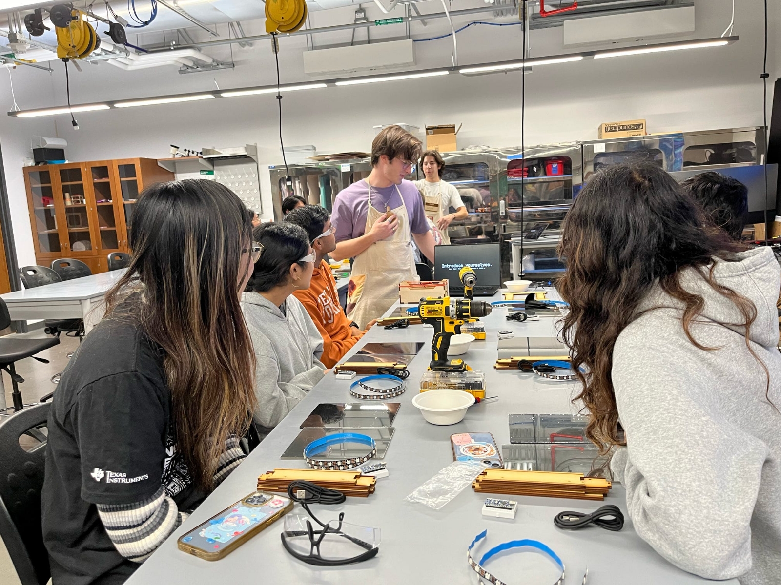 Texas engineering students listening to project demo from TIW student staff