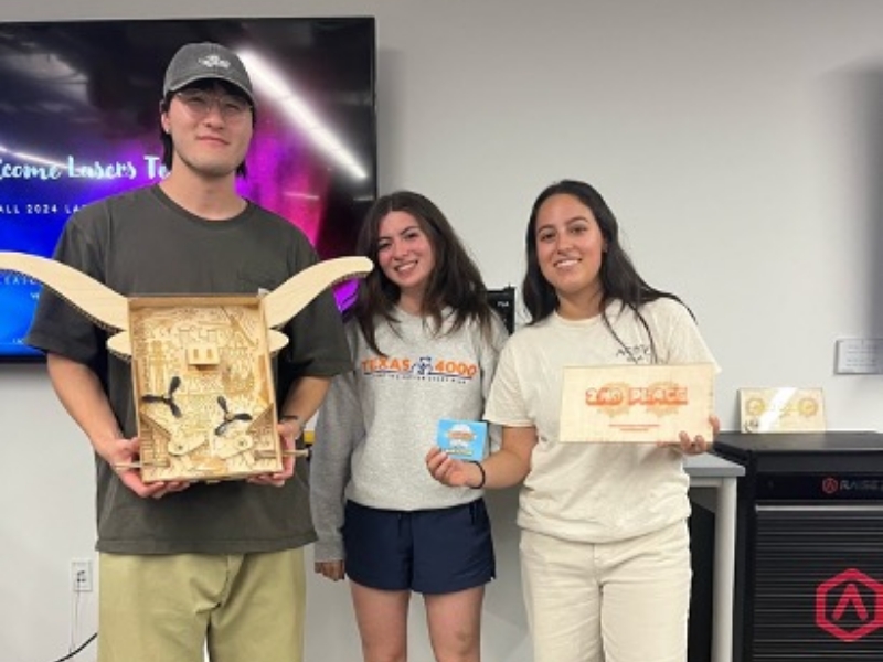 Texas engineering students holding laser project and award for TIW lasers competition