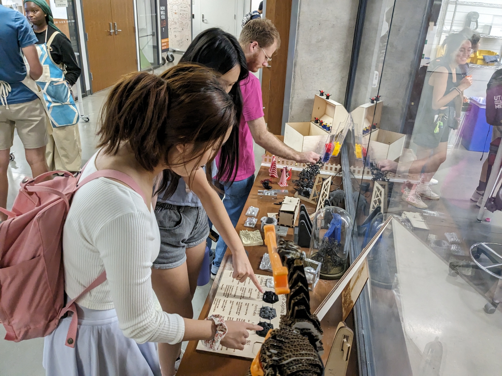 Texas engineering students studying a display at TIW open house