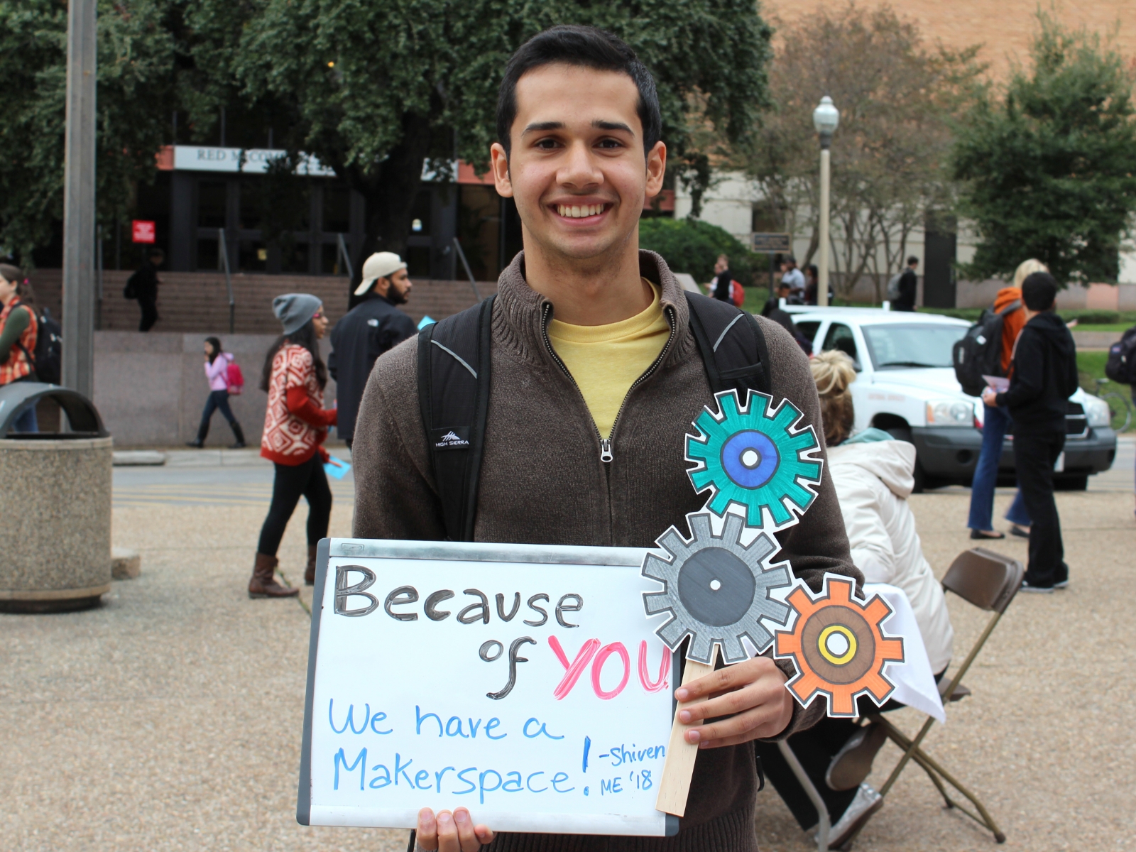 Texas engineering student holding thank you sign with drawing of gears